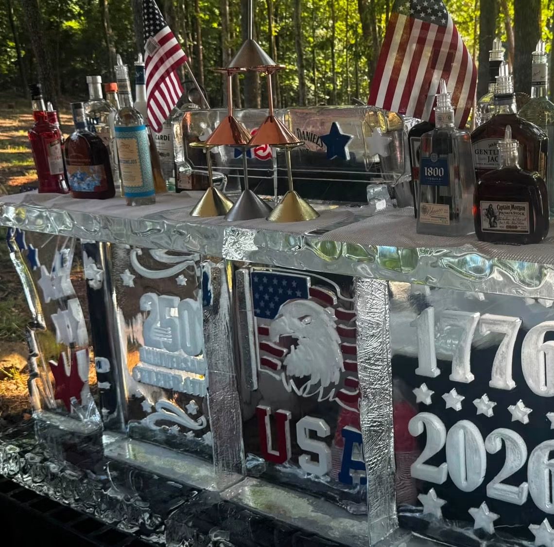 A working bar carved out of blocks of ice, engraved with an eagle and 1776 to 2026, top-shelf liquor and a Jack Daniels ice luge standing on top